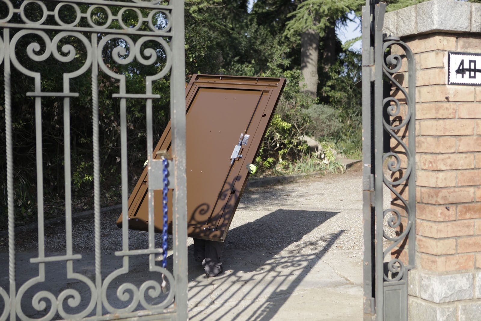 Els operaris portant la porta de seguretat que instal·laran a l'edifici. FOTO: Artur Ribera 