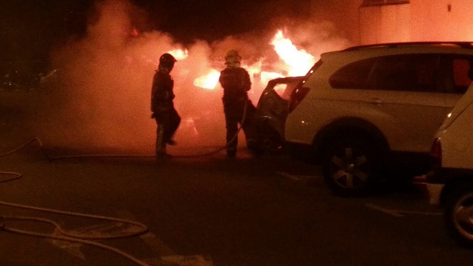 Bombers apagant les flames del cotxe incendiat a Sant Cugat.