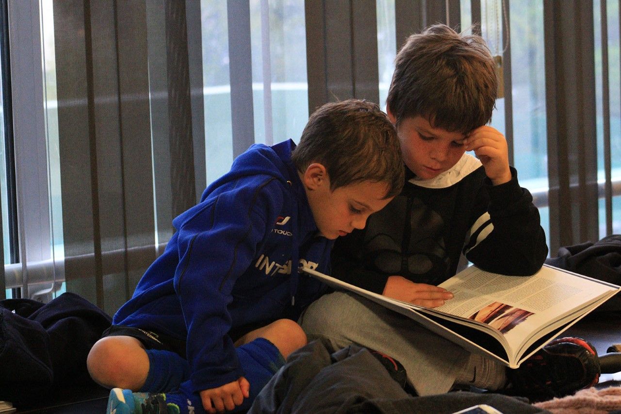 Dos nens del Junior FC, fullejant el llibre del centenari. FOTO: Lali &Aacute;lvarez