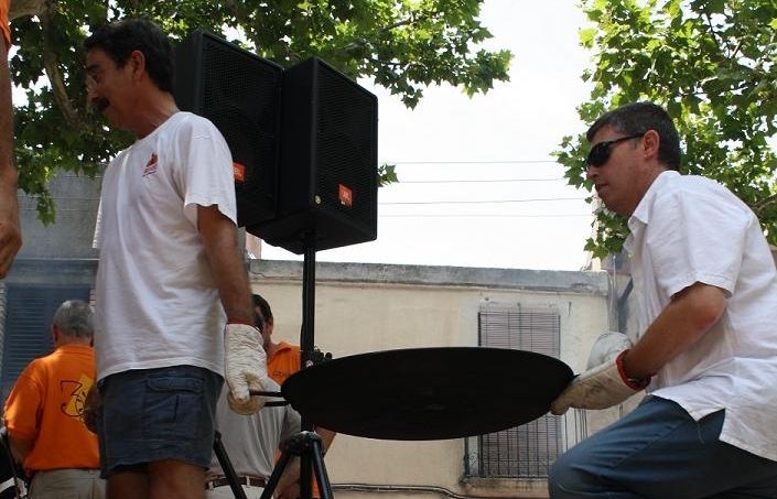 Uns concursants presenten la seva paella al jurat