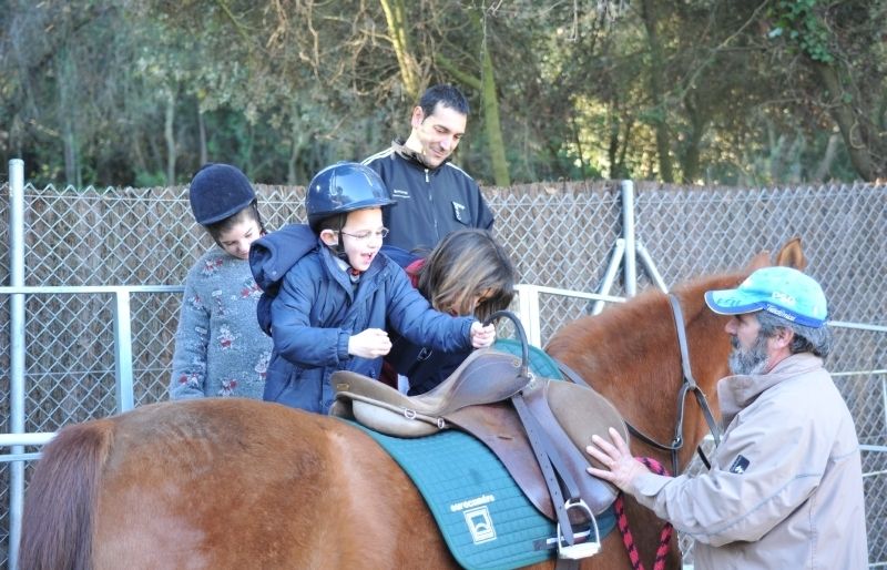 Un nen content de muntar a cavall en una sessió dhipoteràpia. FOTO: Amanda Bernal