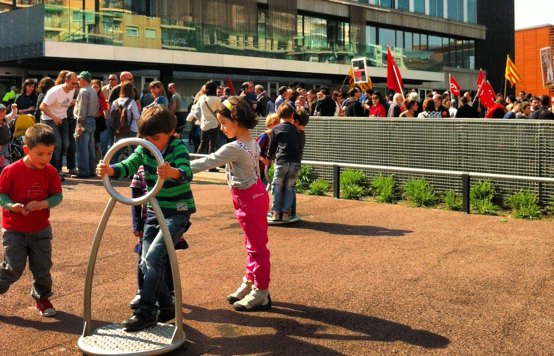 Uns nens juguen davant l'Ajuntament aliens a les protestes darrere FOTO: JR Armadàs