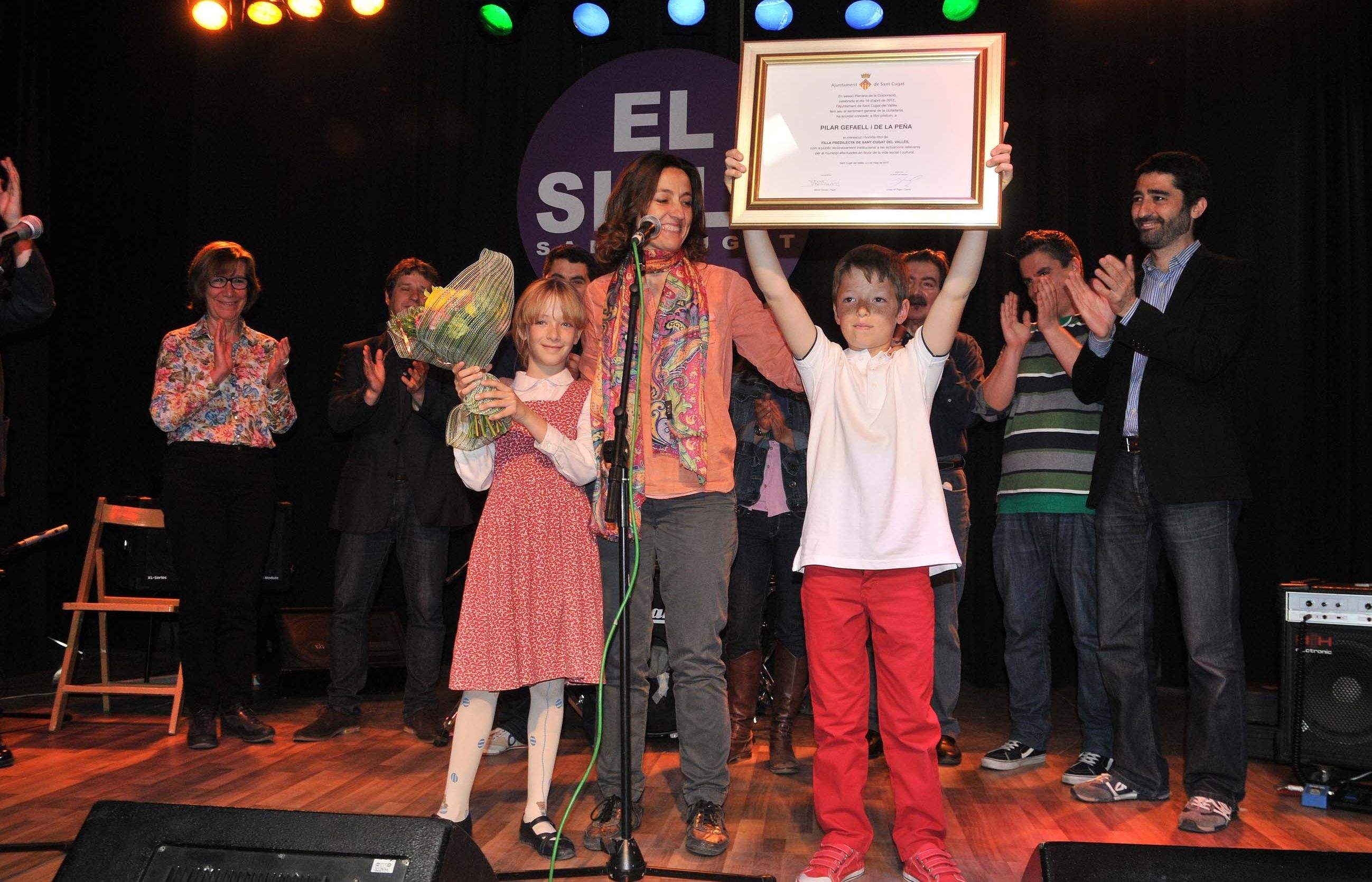 Conesa fent l'entrega de la madalla als seus dos fills bessons. FOTO: Localpress