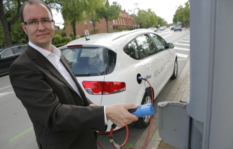 Santiago Cascante endollant el cotxe elèctric. FOTO: Artur Ribera