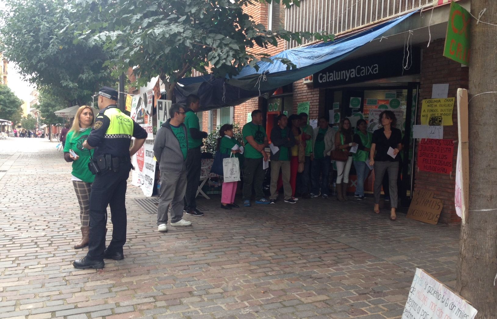 Un policia identificant als membres de la PAH, acampants al carrer de Villà. FOTO: Mariona Sagalés