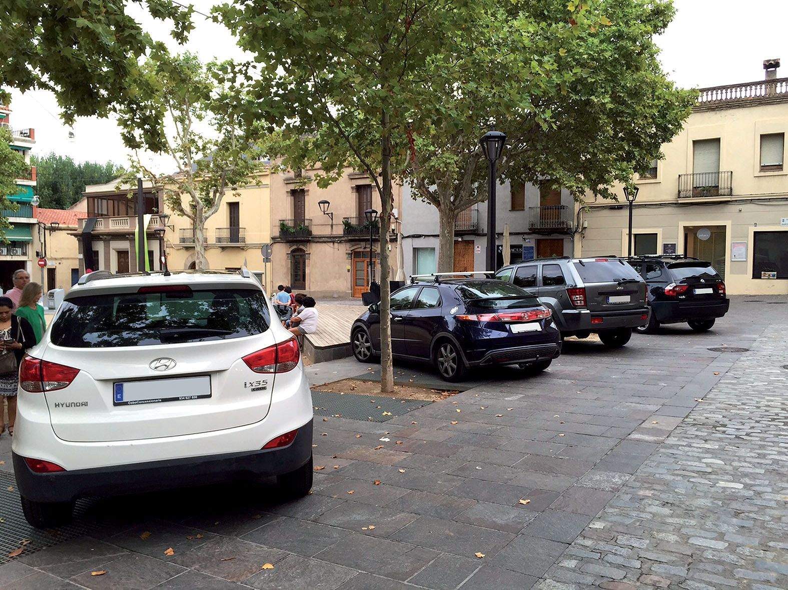 Quatre vehicles estacionats a la Plaça Barcelona. 