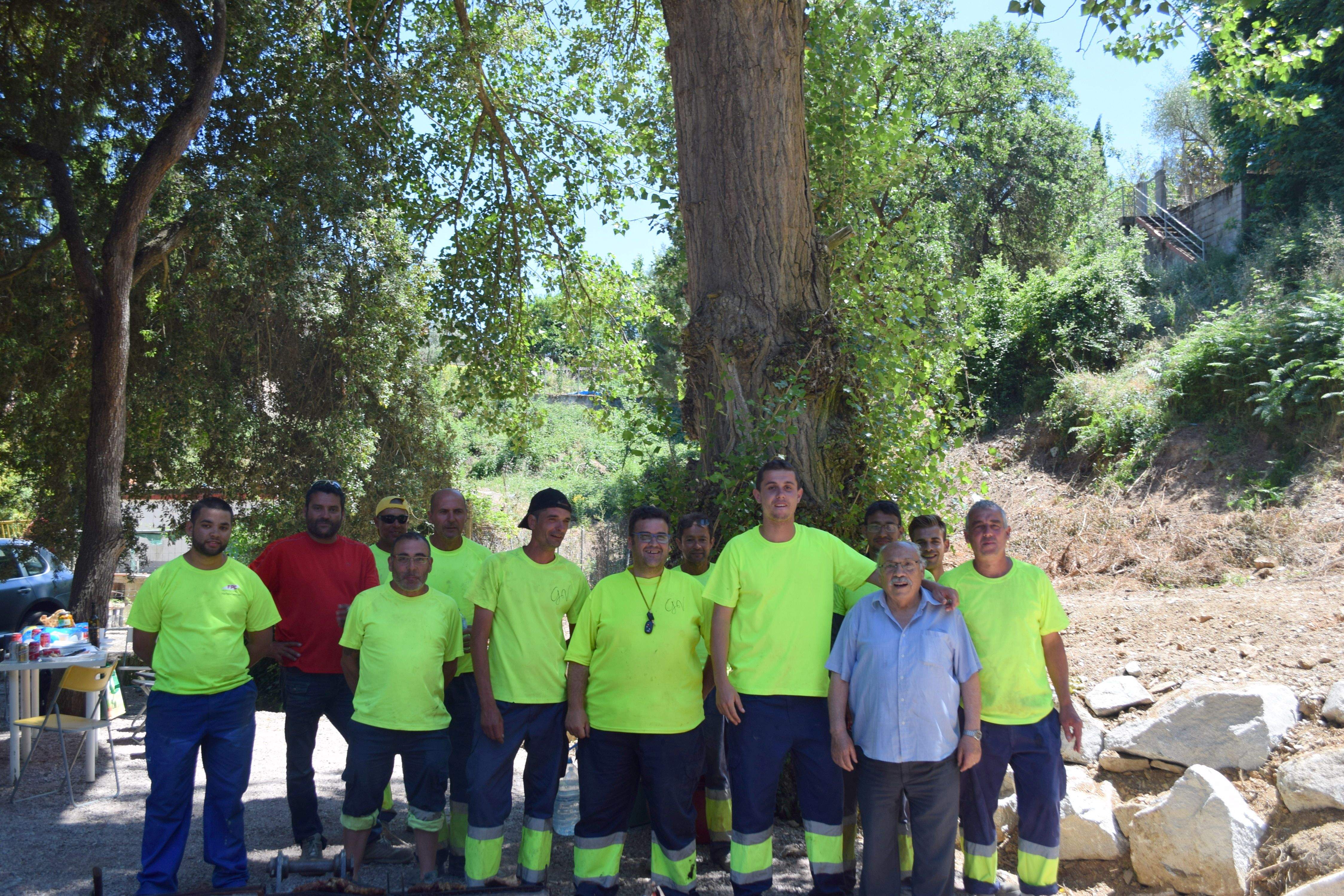 Els operaris que han arranjat la zona, junt amb un dels impulsors de l'arbre democràtic Francisco Artero. FOTO: Cedida