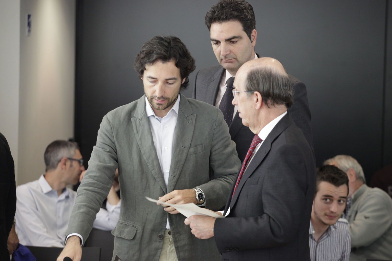 Benejam (PP) mirant-se el ROM de mà del secretàri