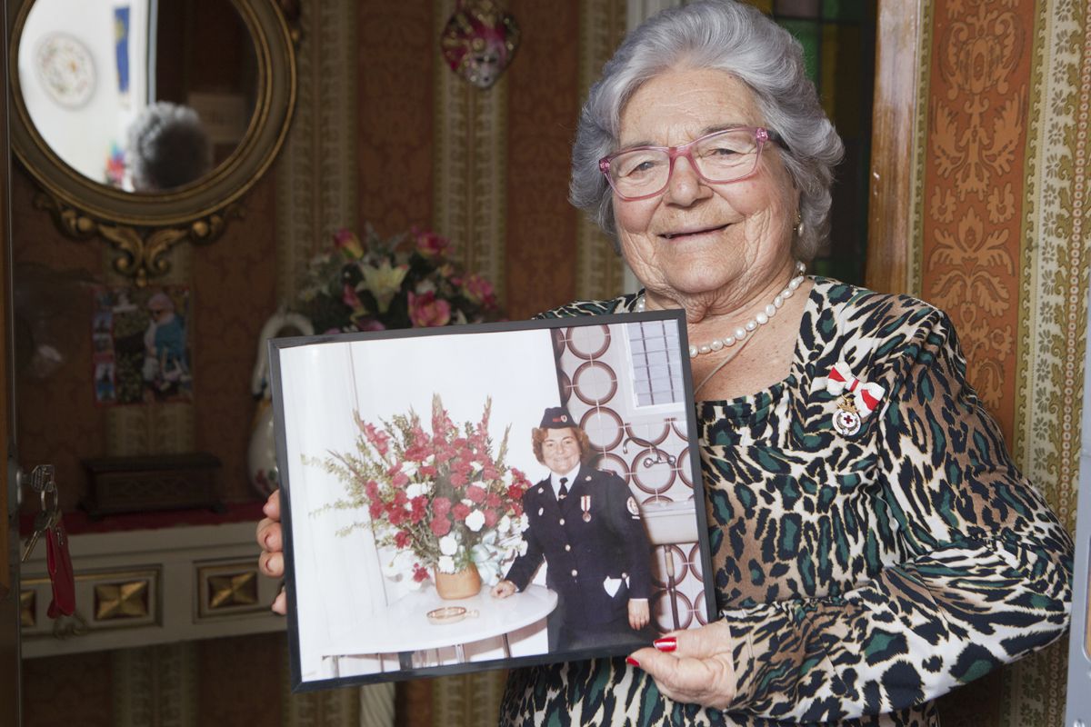 L’Antònia amb una foto antiga de la seva etapa a la Creu Roja i la medalla de plata de la institució FOTO: Artur Ribera 
