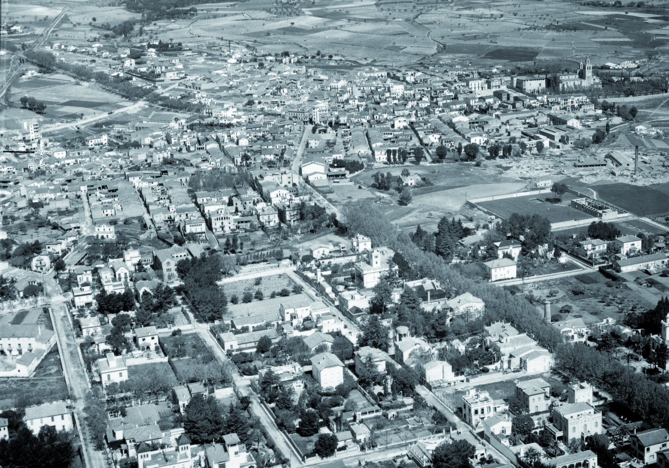 L’avinguda de Gràcia, la via arbrada de la banda dreta en una foto aèria dels anys cinquanta. Autor: Desconegut. Fons Josep Maria Casas Eroles, AHSCV.