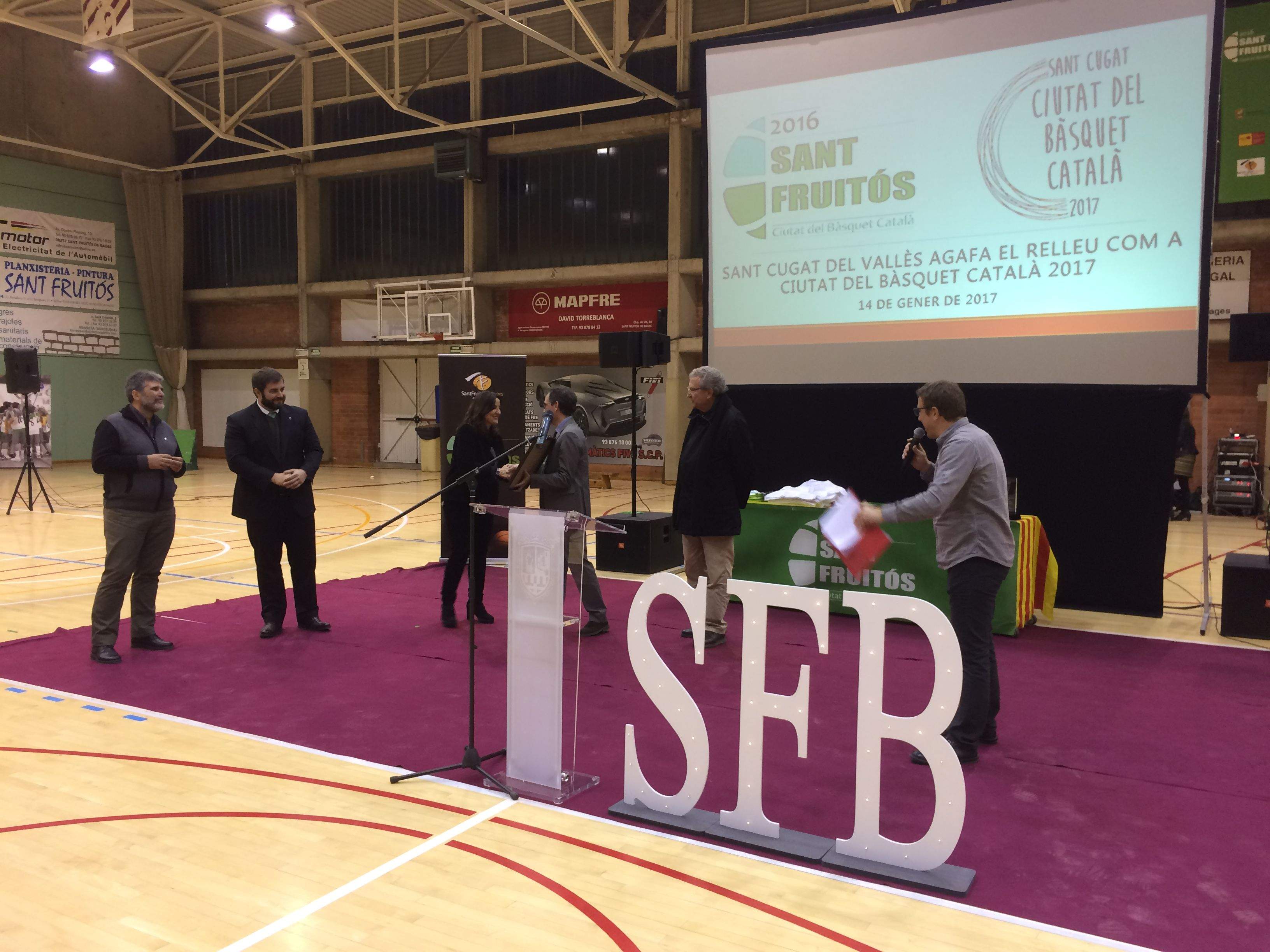 Carles Batanés fa el traspàs a Mercè Conesa de la Ciutat del Bàsquet Català. FOTO: Àlex López Puig