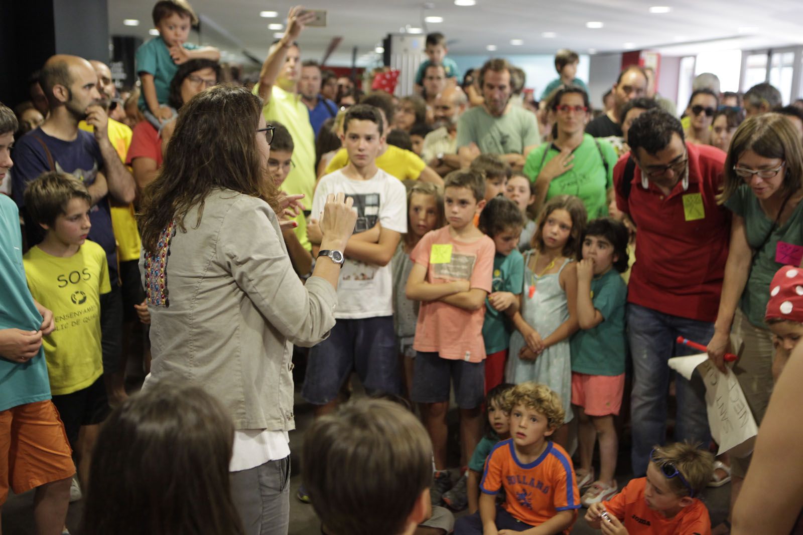 L'alcaldessa Mercé Conesa demana silenci al nombrós grup de pares, mares i nens a les portes del plenari