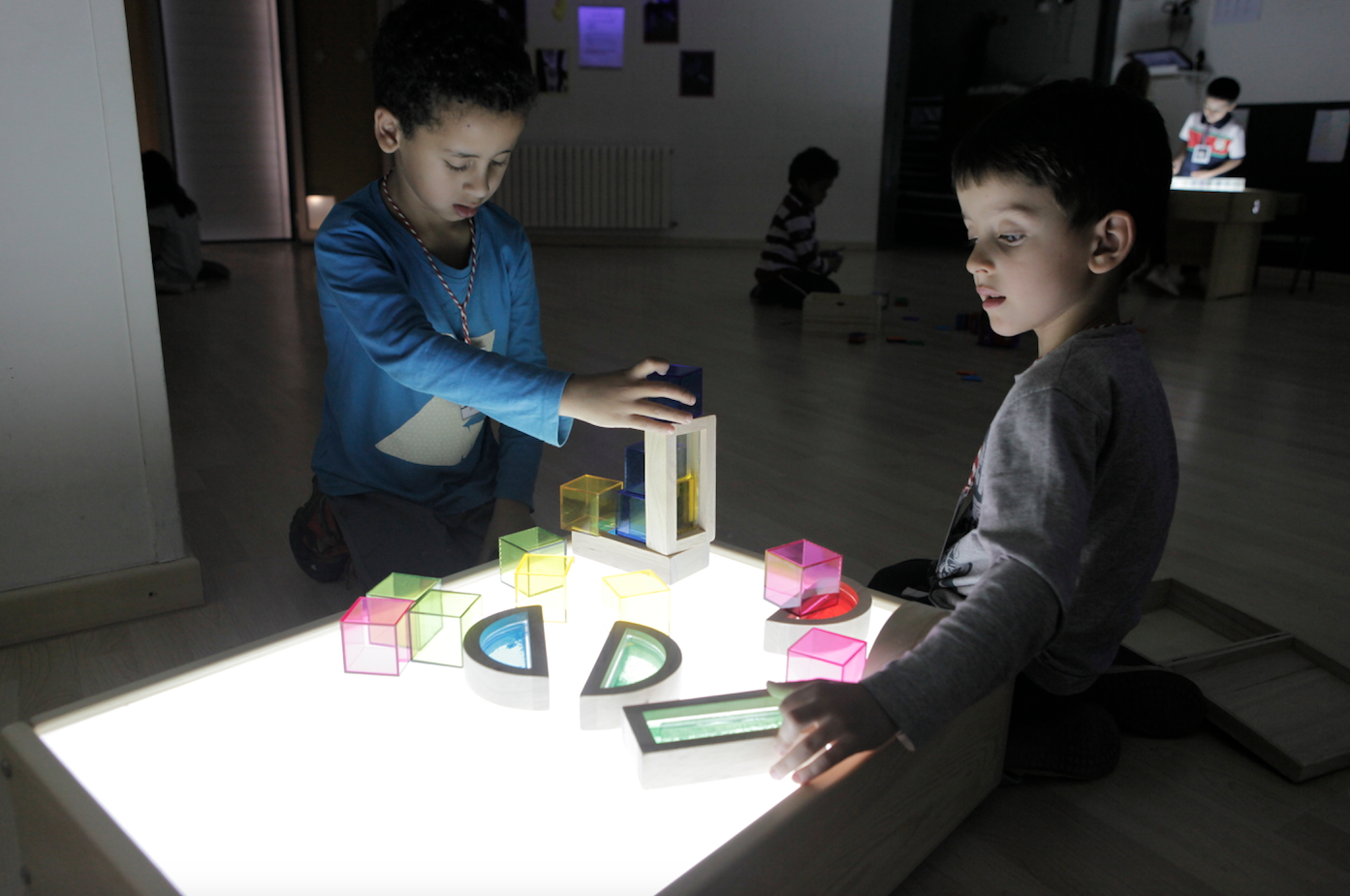 Uns nens gaudeixen amb taules de llum a la seva escola FOTO: Artur Ribera