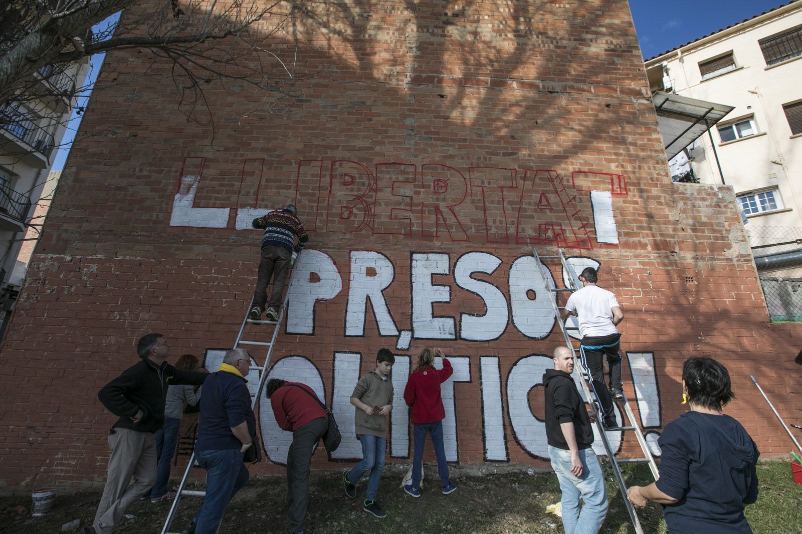 Diversos activistes fent el mural aquest diumenge, 14 de gener, al matí FOTO: Lali Puig 