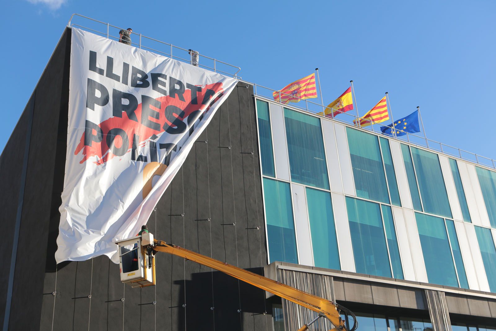 Moment de col·locació de la pancarta per part dels operaris municipals el 15 de març. FOTO: Artur Ribera. 