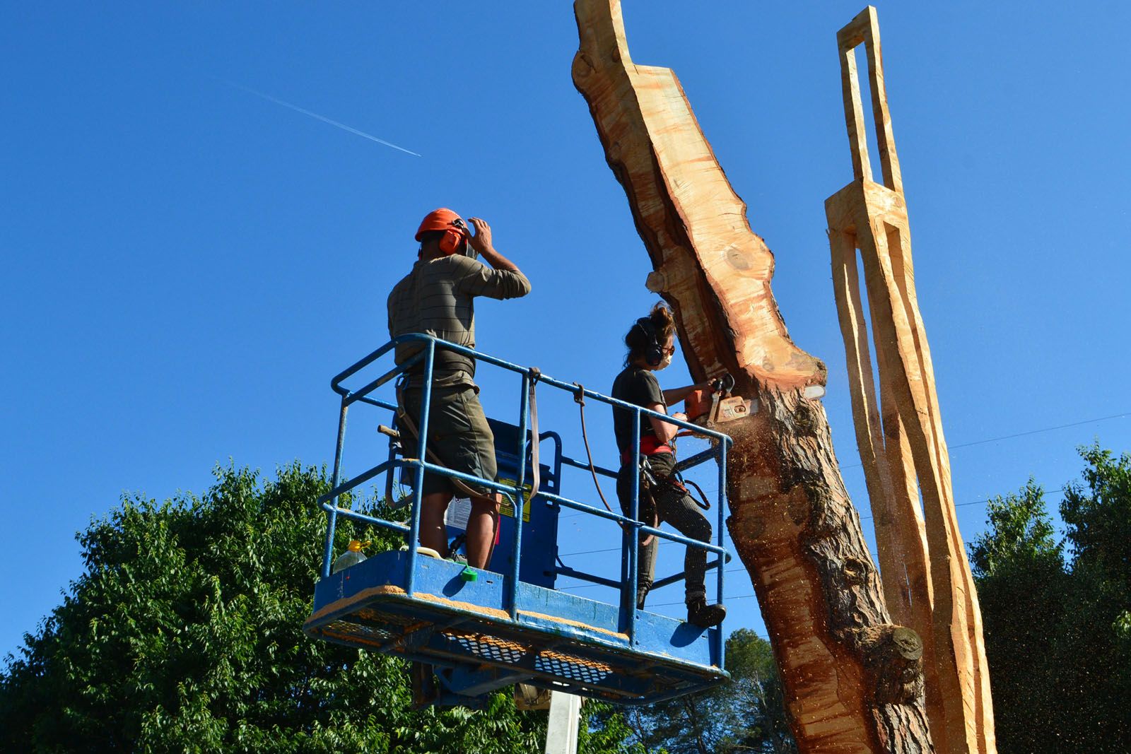 Imatge dels artistes completant la conversió del pi de l'Estació de Valldoreix en obra artística. FOTO: Cedida