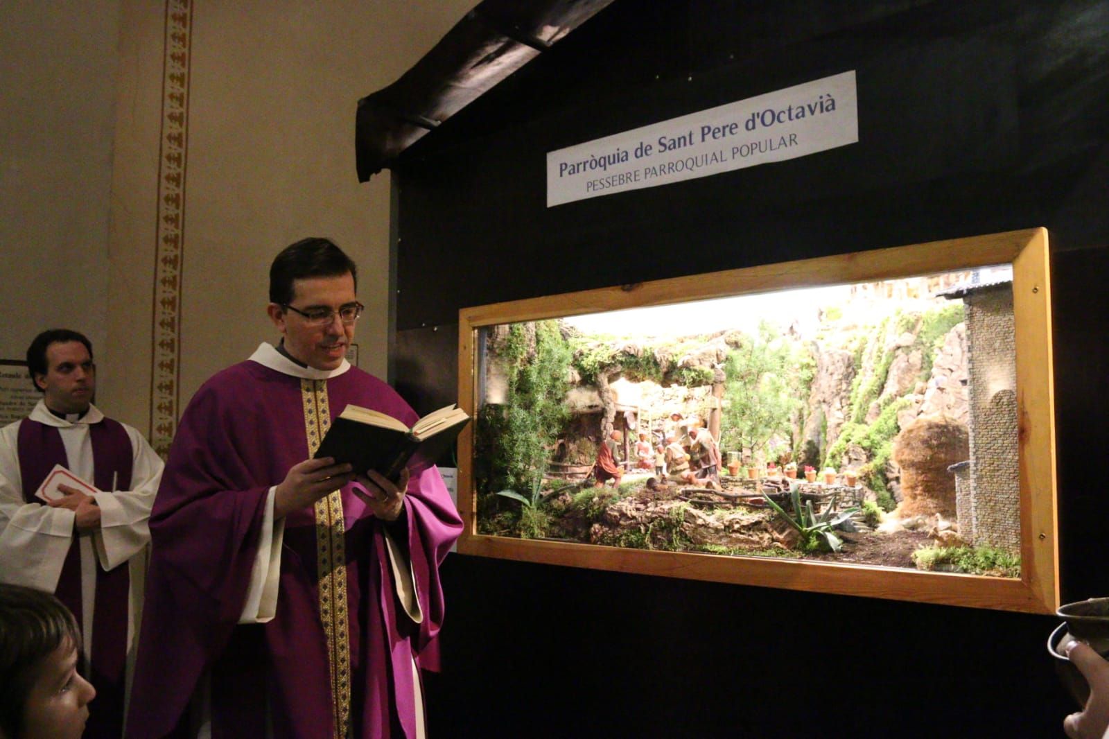 Mn. Emili fent la benedicció del pessebre de la Parròquia de Sant Pere d'Octavià. FOTO: Lali Álvarez