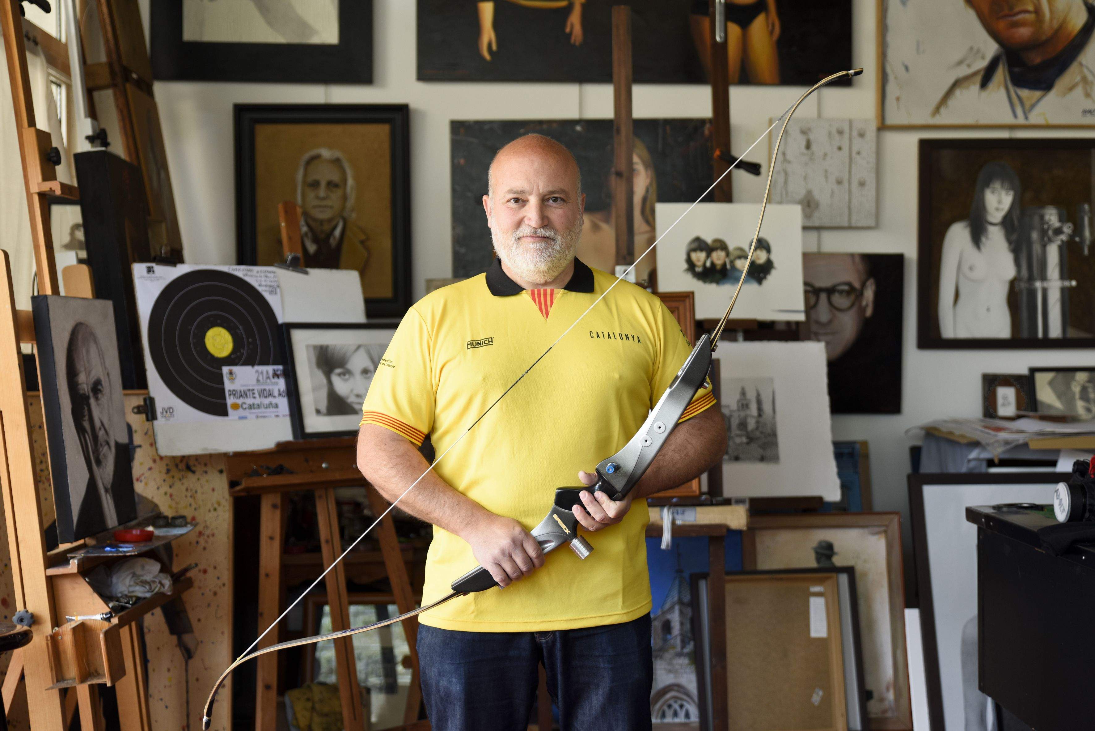 Adolf Priante en el seu estudi a Valldoreix, amb la samarreta dela selecció catalana i el seu arc. FOTO: Bernat Millet