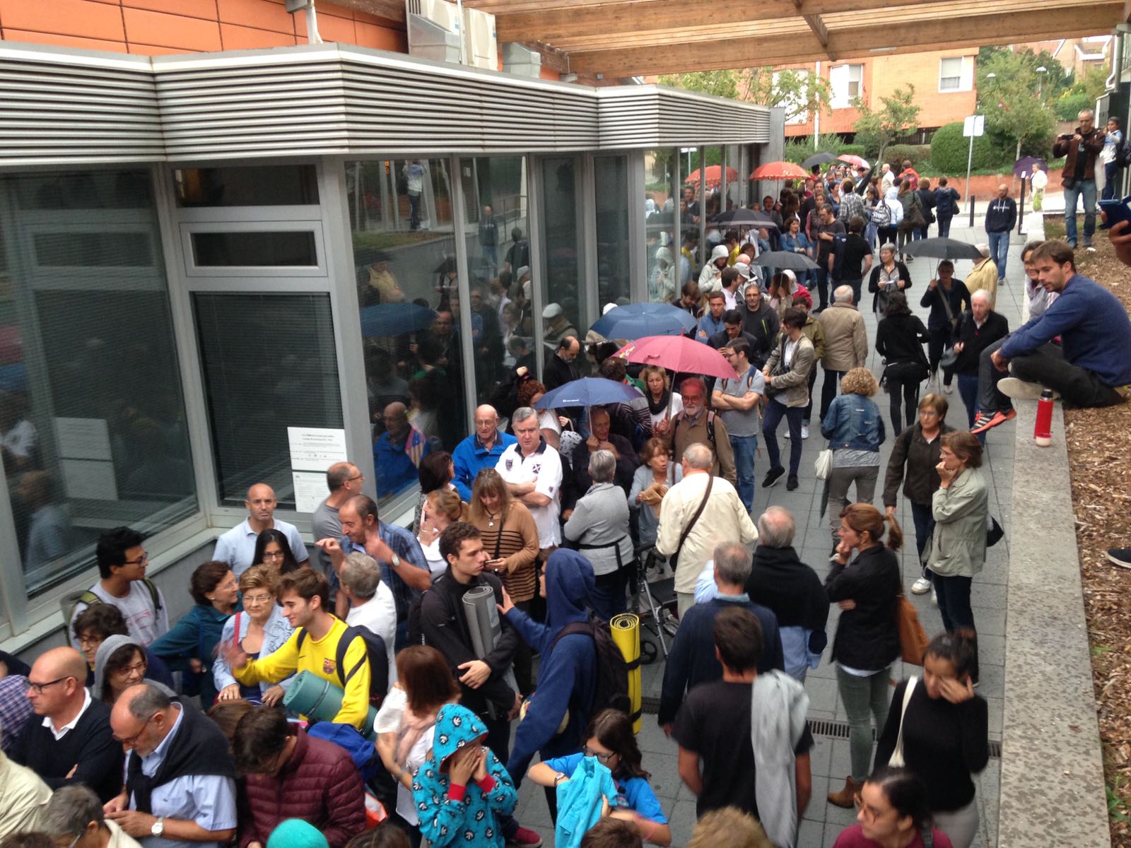 Les cues sota la pluja. Foto: cedida