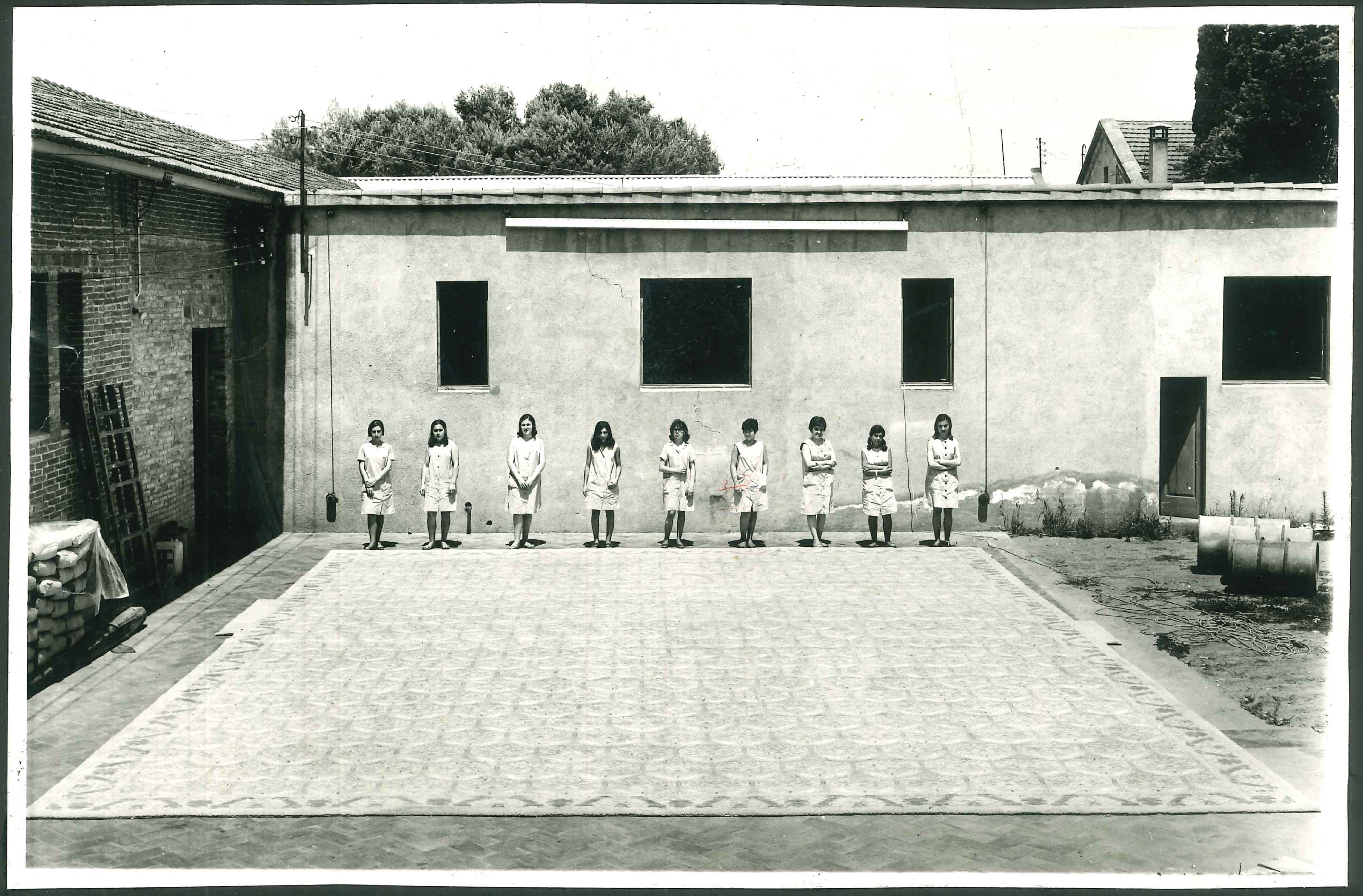 Teixidores amb la catifa de gran format acabada i a punt per anar als Estats Units. Fons Cabanas (fotògraf). AMSCV