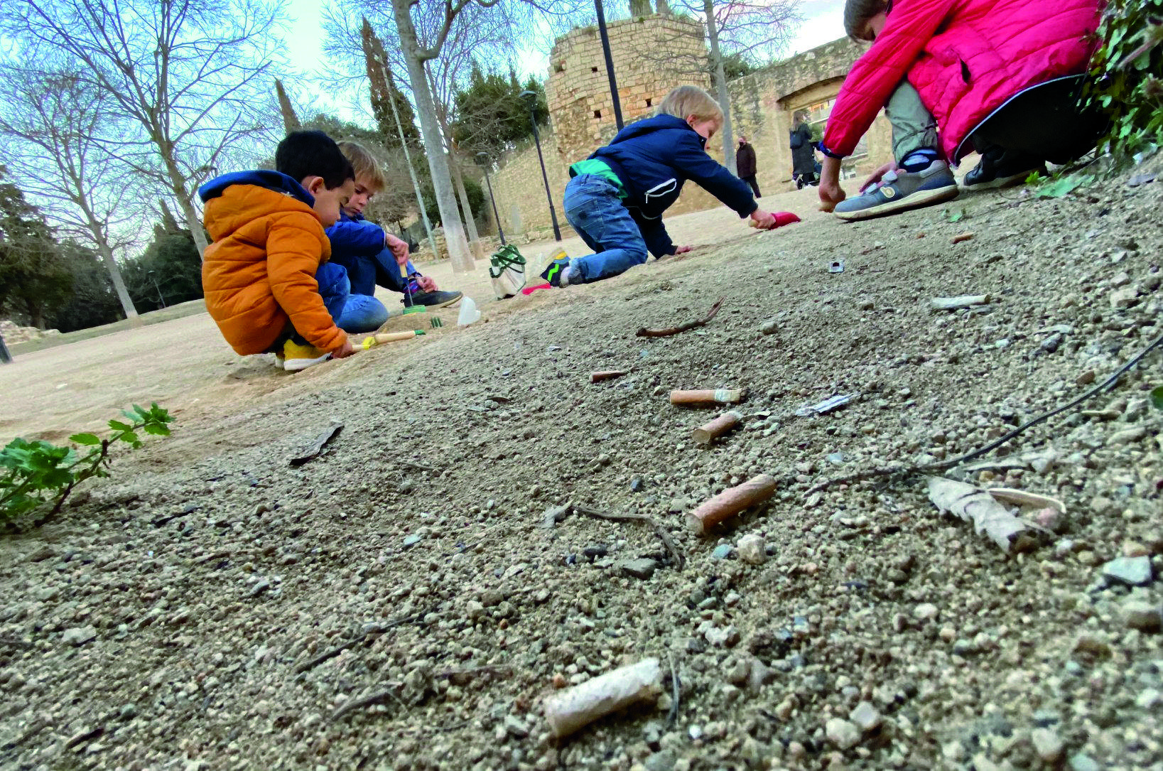 Un grup de nens juga amb la sorra a pocs metres d'unes colilles de cigarret. FOTO: JR Armadàs