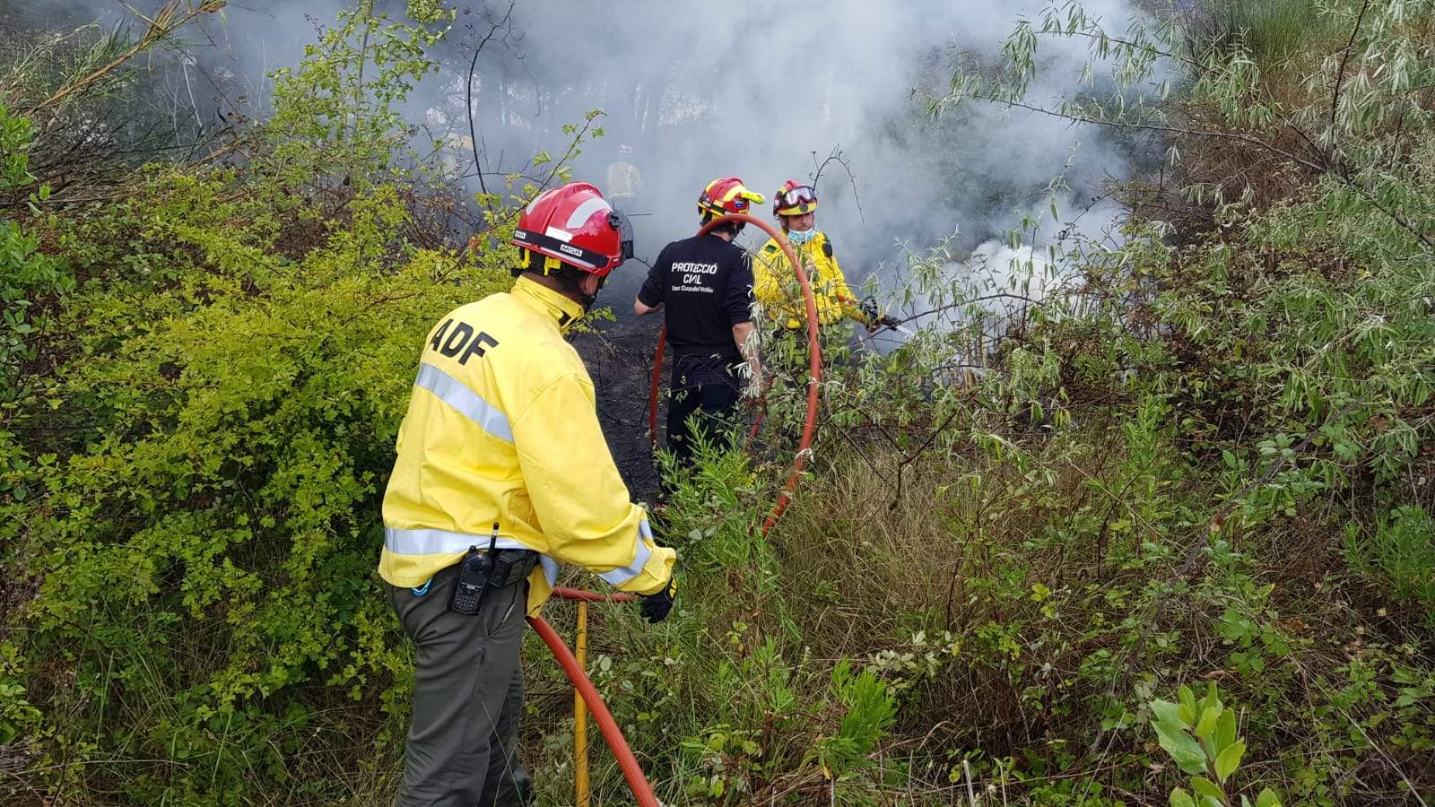 Personal d'ADF i Protecció Civil treballant en l'incendi de matolls al parc Central. FOTO: Cedida