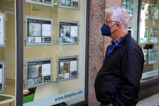 Pla mitjà d'una persona mirant les ofertes de pisos a un aparador d'una immobiliària FOTO: ACN / Marta Casado