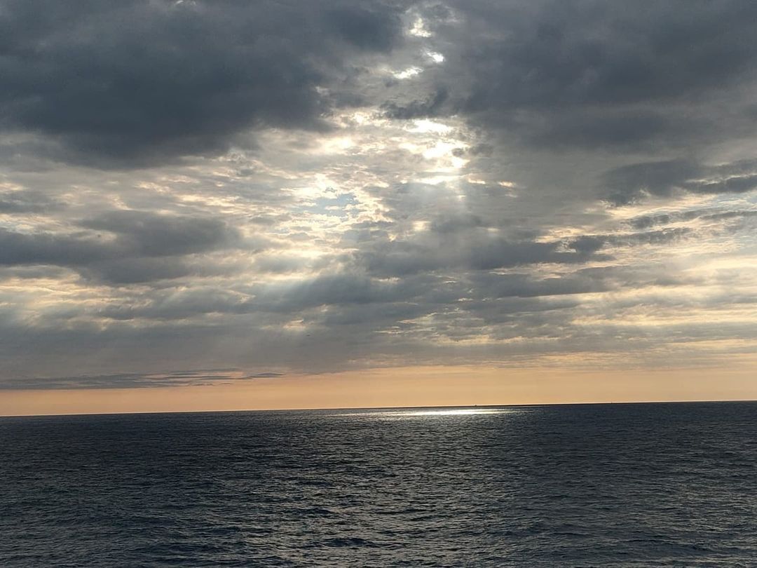@mai_platja_daro - El sol sortint entre el mar de núvols emmirallant se a la mar 