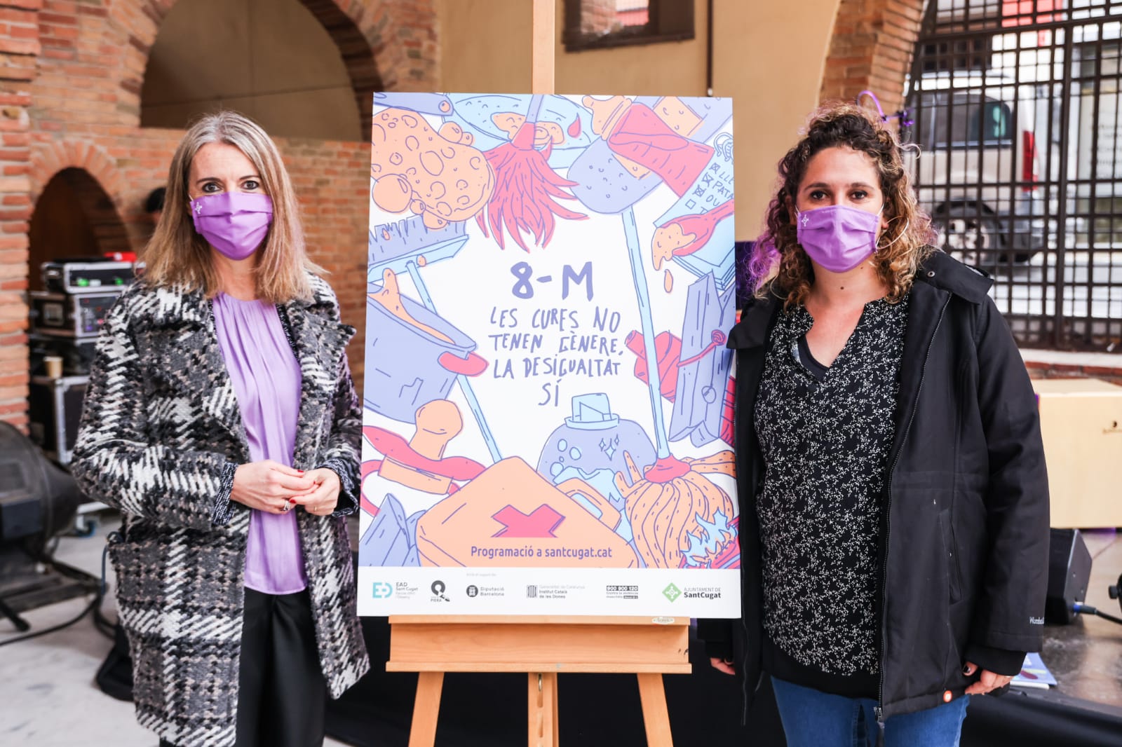 Mireia Ingla i Núria Gibert amb el cartell del Dia de la Dona 2022 a l'acte institucional de Sant Cugat. FOTO: Lali Puig