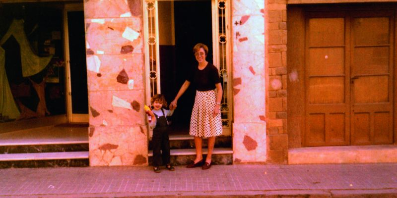 El primer local del Centre d’Estudi de Llengües al c/ Santiago Rusiñol; a la porta una jove M. Obiols amb la seva filla Mònica, el 1976. Foto: Cedida