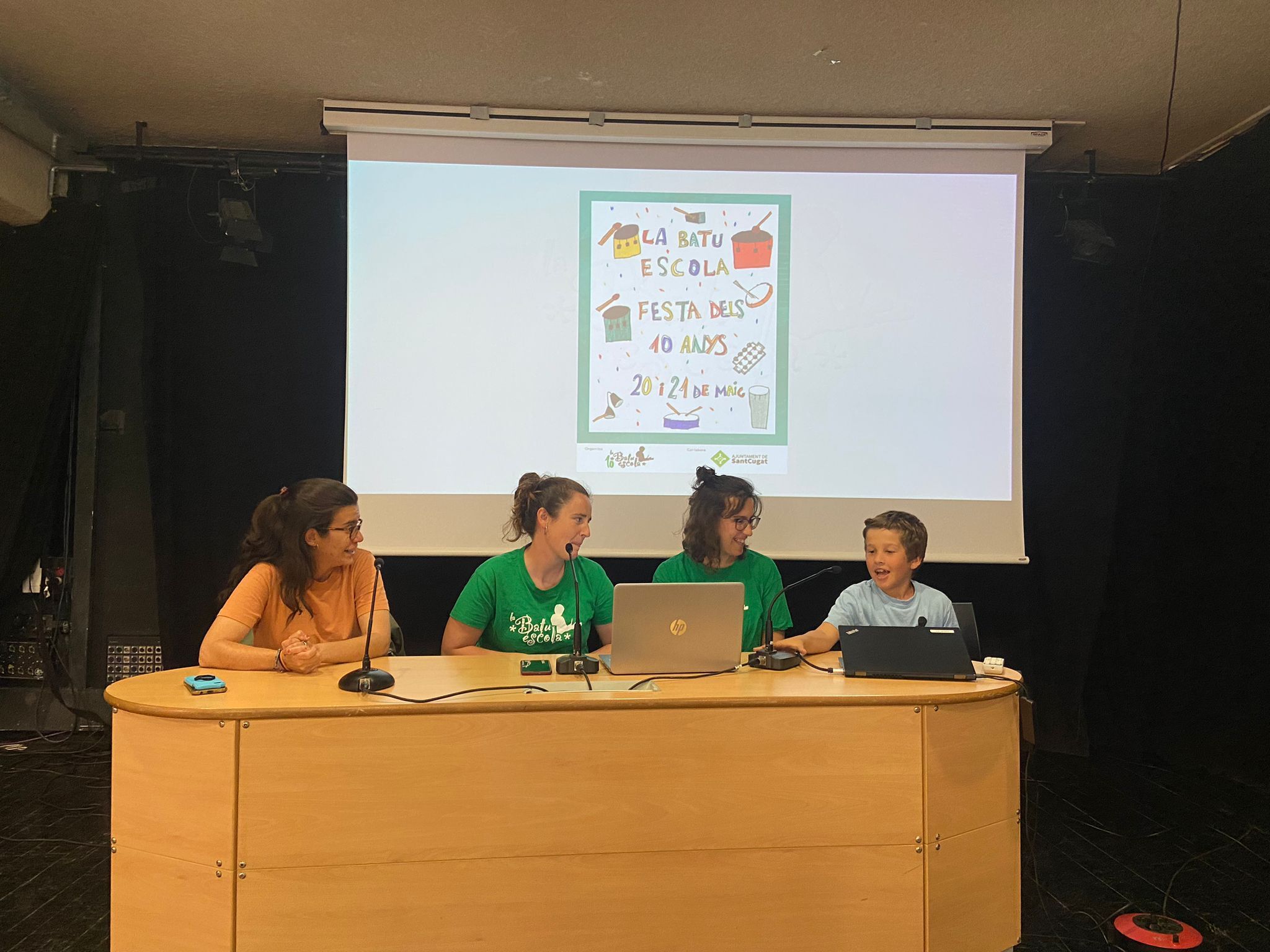 La tinenta d'alcaldia de Cultura, Esther Madrona, les membres de la Junta de la Batuescola, Berta Marquès i Laia Serra, i el Pol, creador del cartell. Foto: Alba M. Vallejo