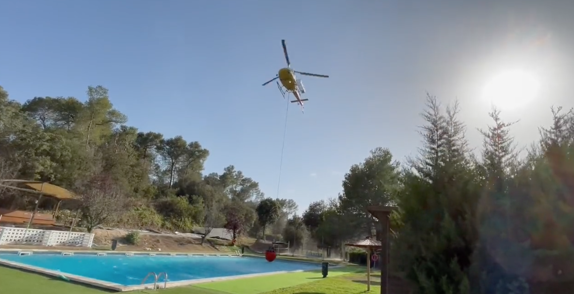 Un helicòpter recollint aigua a la piscina del Club Esportiu Valldoreix per apagar un incendi de Molins de Rei. FOTO: EMD Valldoreix
