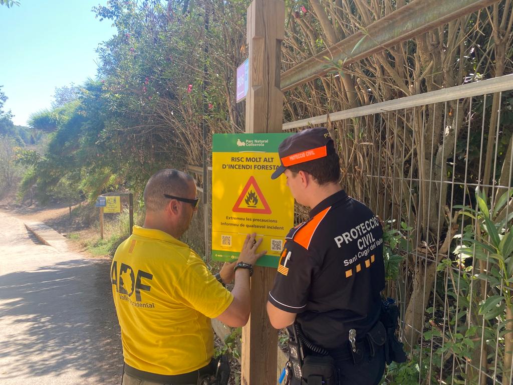 ADF i Protecció Civil penjant cartells a les entrades de Collserola FOTO: Cedida