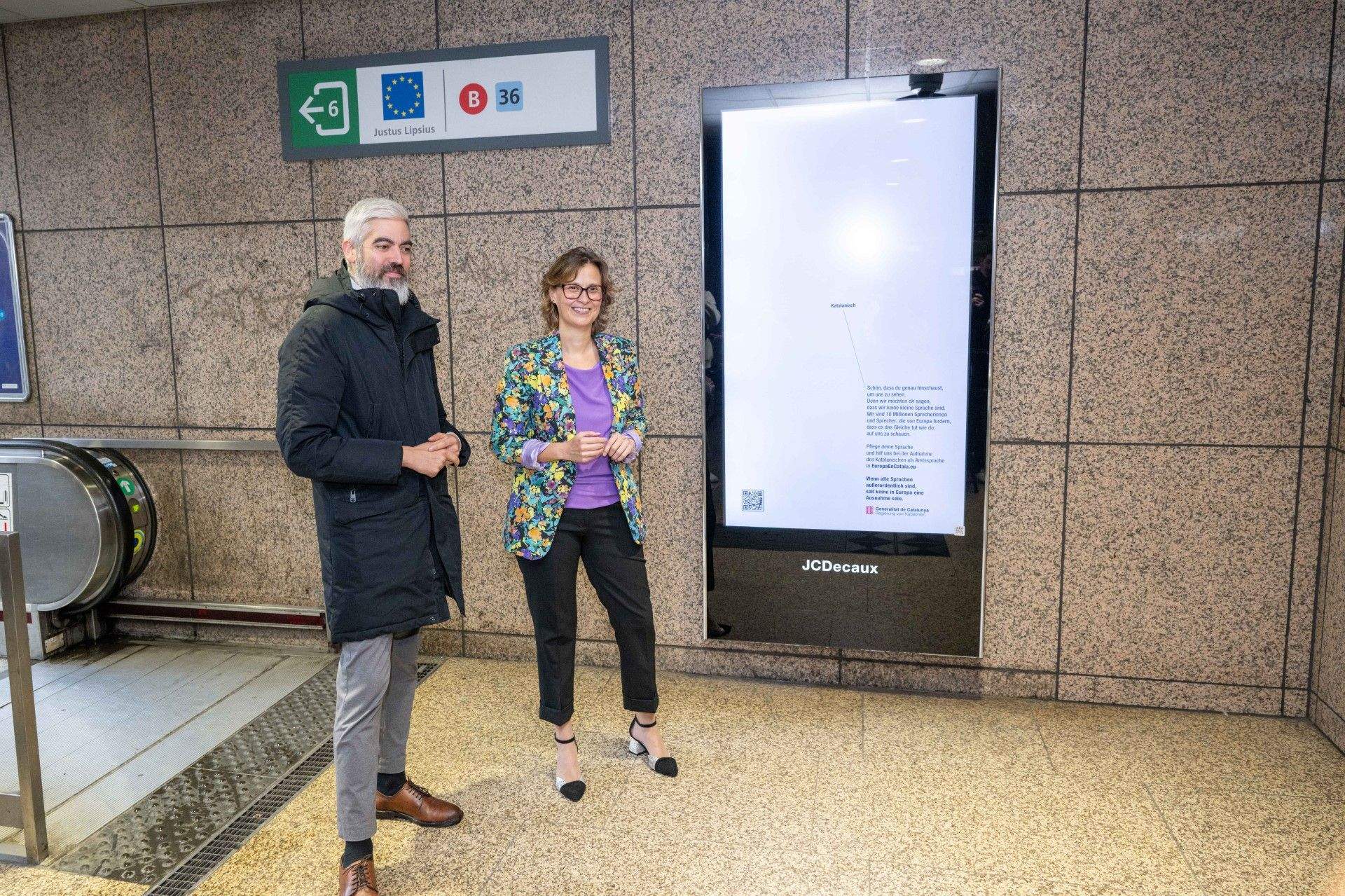 La consellera Meritxell Serret i el delegat davant la UE, Ignasi Centelles, a la parada de metro Schuman a Brussel·les, on hi ha instal·lat un anunci. FOTO: Govern de la Generalitat