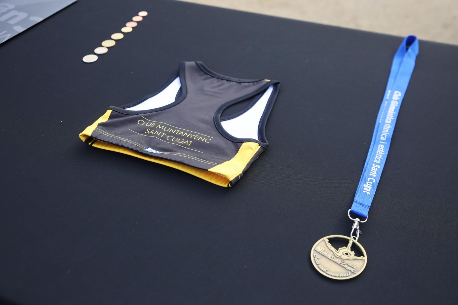 El Club Muntanyenc Sant Cugat (amb una equipació) i el Club Gimnàstica Rítmica i Estètica Sant Cugat (amb una medalla) han participat en la col·locació de la primera pedra del nou pavelló. FOTO: Ajuntament