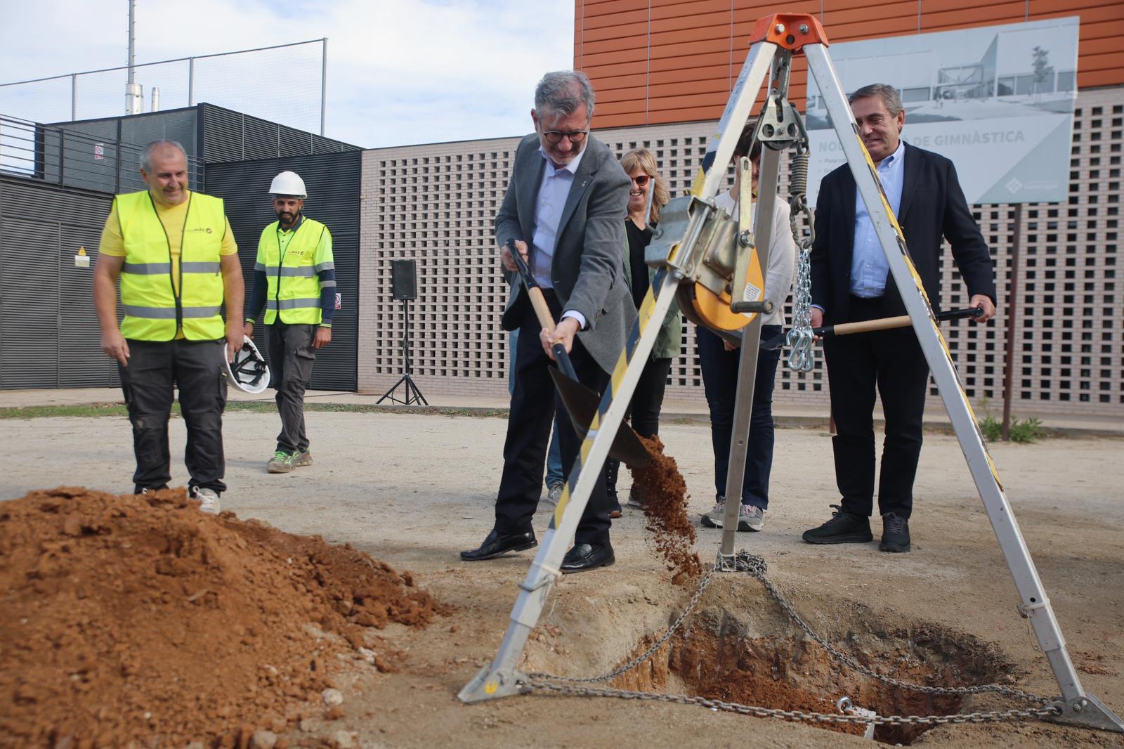 L'alcalde de Sant Cugat, Josep Maria Vallès, ajundant a enterrar la primera pedra del nou pavelló d'entrenament de gimnàstica a la Guinardera. FOTO: Ajuntament