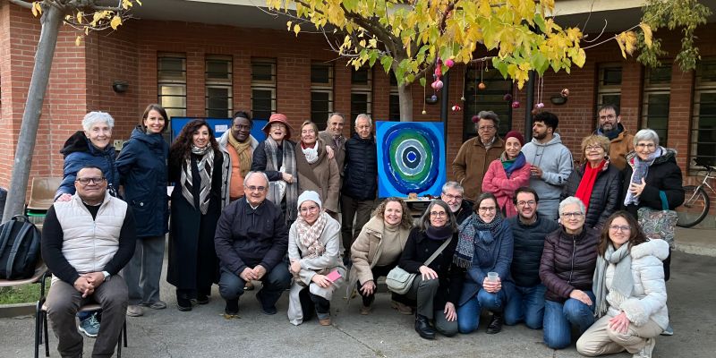 Assistents a l'activitat organitzada pel Casal Arrupe i la comunitat bahá'í a la Nit de les Religions de Sant Cugat amb el mural de fons. FOTO: Cedida