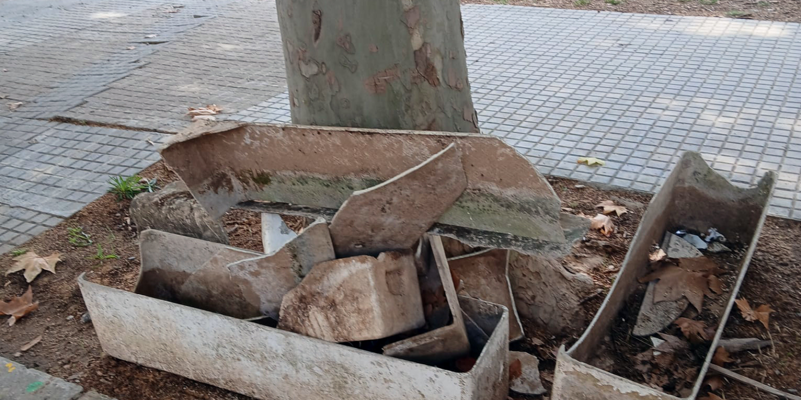 Jardineres trencades i sense protecció al costat dels contenidors