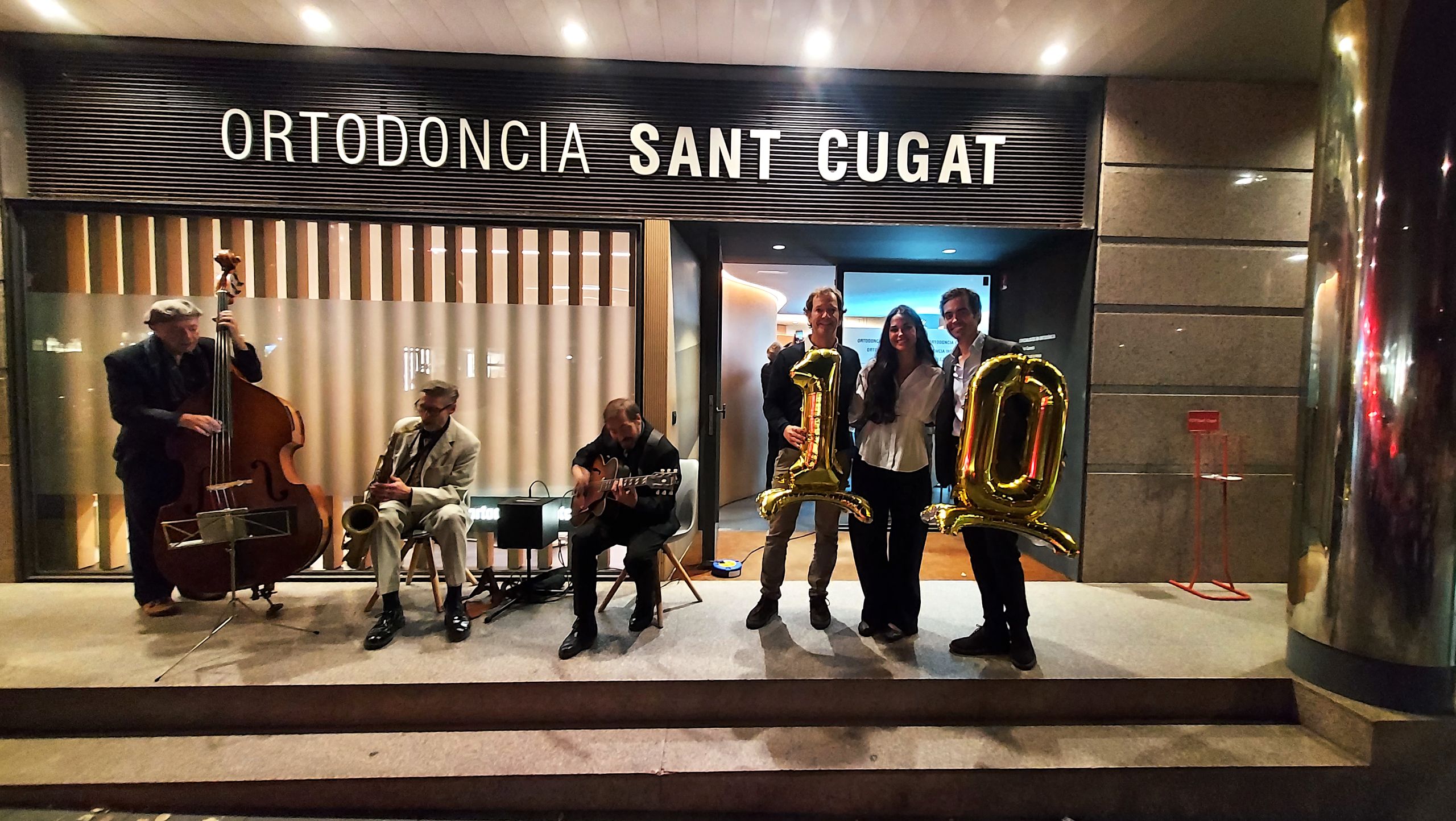 Els fundadors d’Ortodoncia Sant Cugat, amb els globus del 10, a la porta del centre durant la celebració.